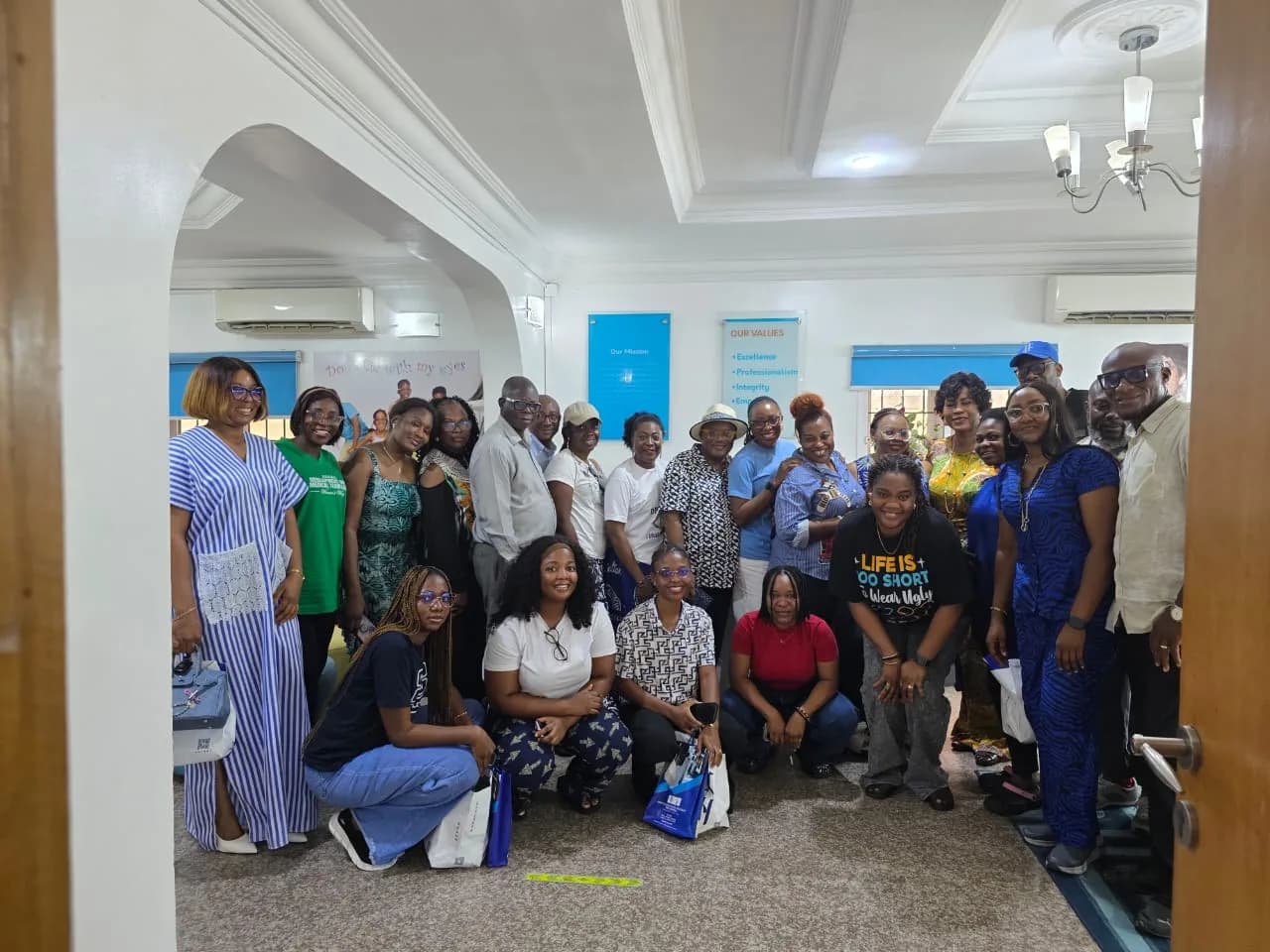 A large group of members in a hall, many wearing blue polo shirts, gathered for a photograph.