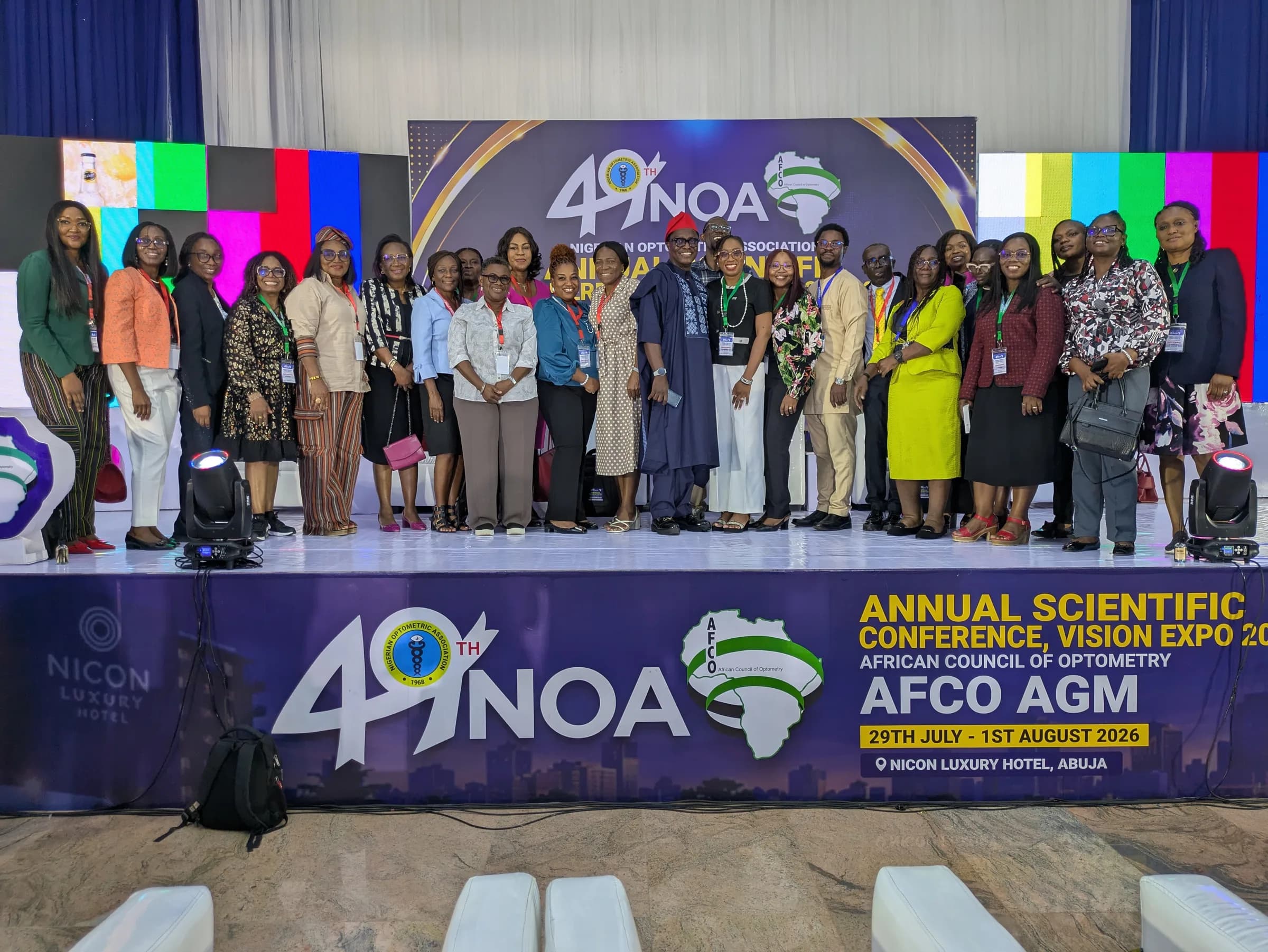 Three members standing in front of the 49th NOA conference backdrop, wearing delegate lanyards.